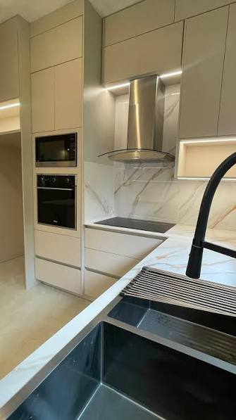 Cocina crema con mármol y campana de acero